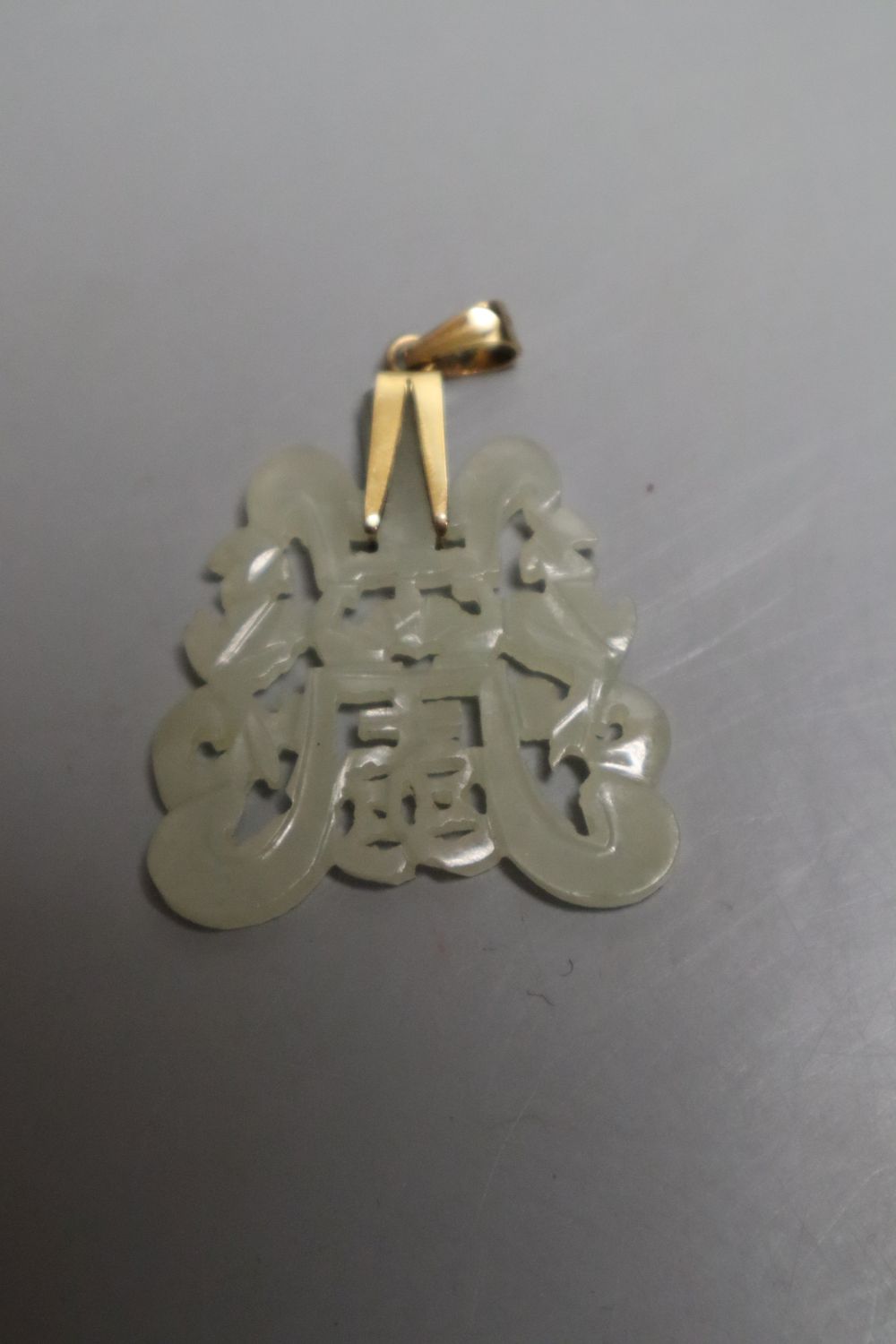 A Chinese pale celadon and russet jade figure of a boy, 4.8cm, a similar carved pendant together with a yellow metal and hardstone set